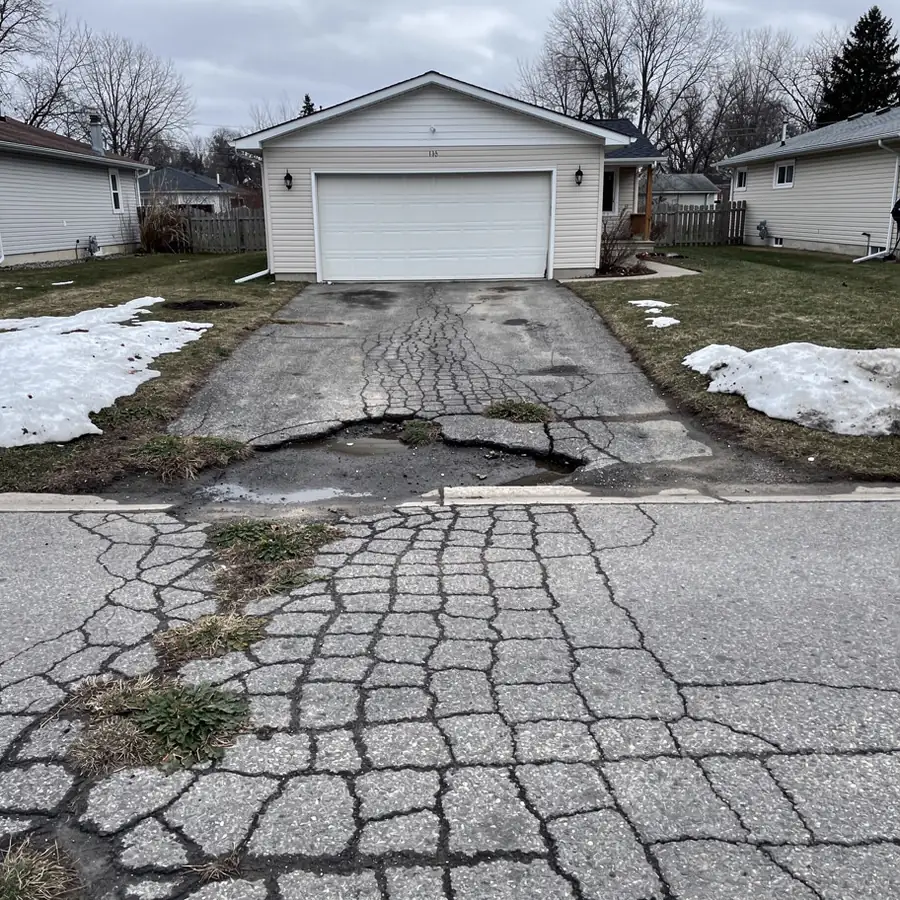 Cracked old driveway before asphalt replacement