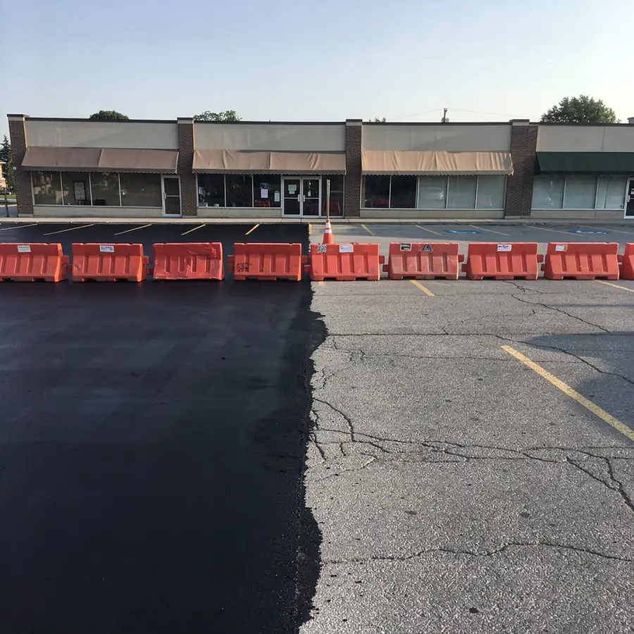 Half sealcoated plaza parking lot with barricades Half sealcoated plaza parking lot with barricades