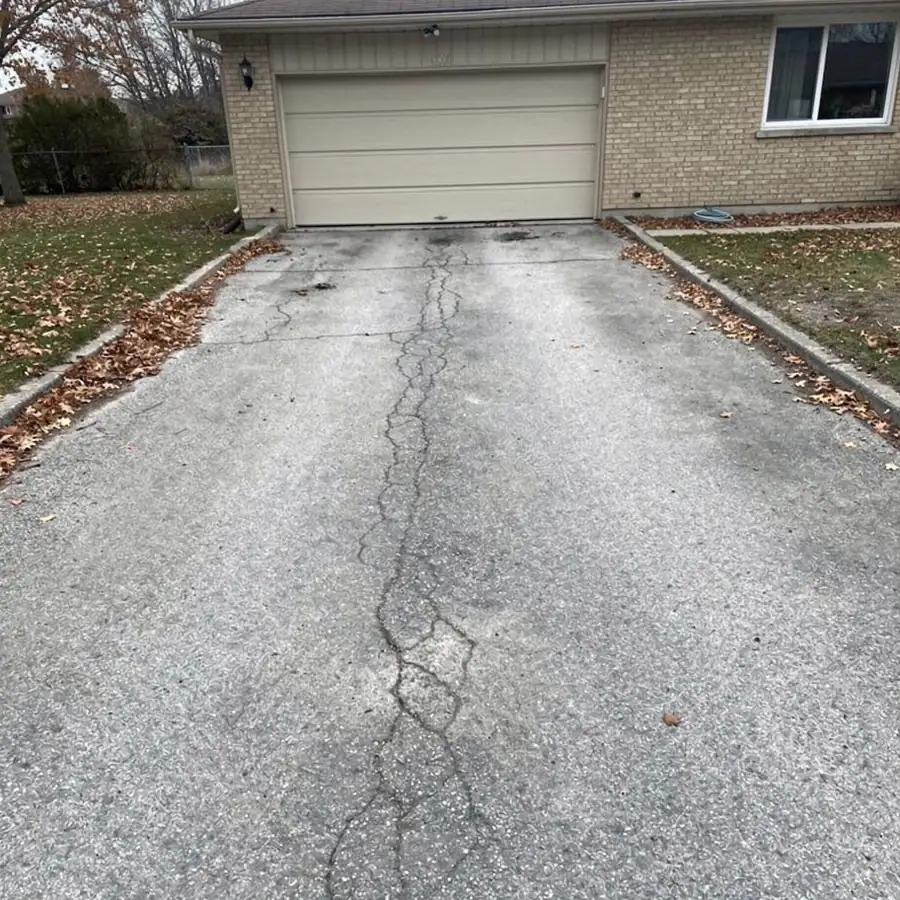 Oxidized grey driveway with hairline surface cracks